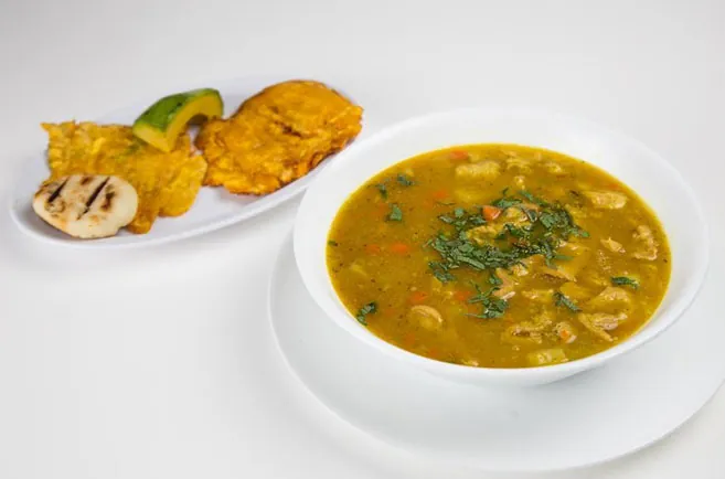 Traditional Colombian soup served with arepa and patacones