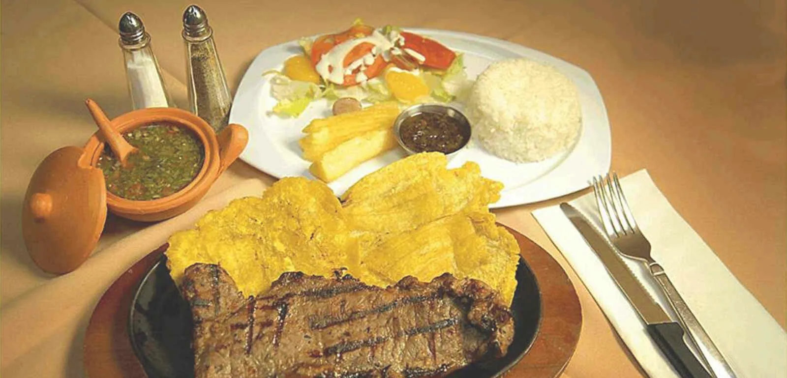 Grilled steak with patacón, rice, yucca and salad at Sabor Colombiano
